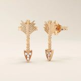 14k solid rose gold arrow-shaped stud earrings, showcasing delicate feathered ends and a pointed tip encrusted with white moissanite stones.
