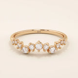 14k solid rose gold band adorned with a sequence of graduated moissanite stones in a delicate pavé setting.

