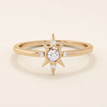 14k solid rose gold band showcasing a starburst motif with a round moissanite center and four accent moissanites.
