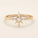 14k solid rose gold band showcasing a starburst motif with a round moissanite center and four accent moissanites.
