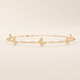 14k solid rose gold butterfly charm bracelet showcasing dainty butterfly designs joined with slim geometric chain links.
