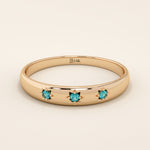 14k solid rose gold dome ring showcasing a trio of aquamarine gemstones accented with engraved star details.