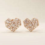 14k solid rose gold heart-shaped stud earrings pavé-set with a mix of baguette and round white moissanite stones, offering a romantic and modern style.
