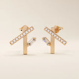 14k solid rose gold modern line studs with a row of sparkling moissanite rounds and a sleek baguette-cut moissanite drop accent.
