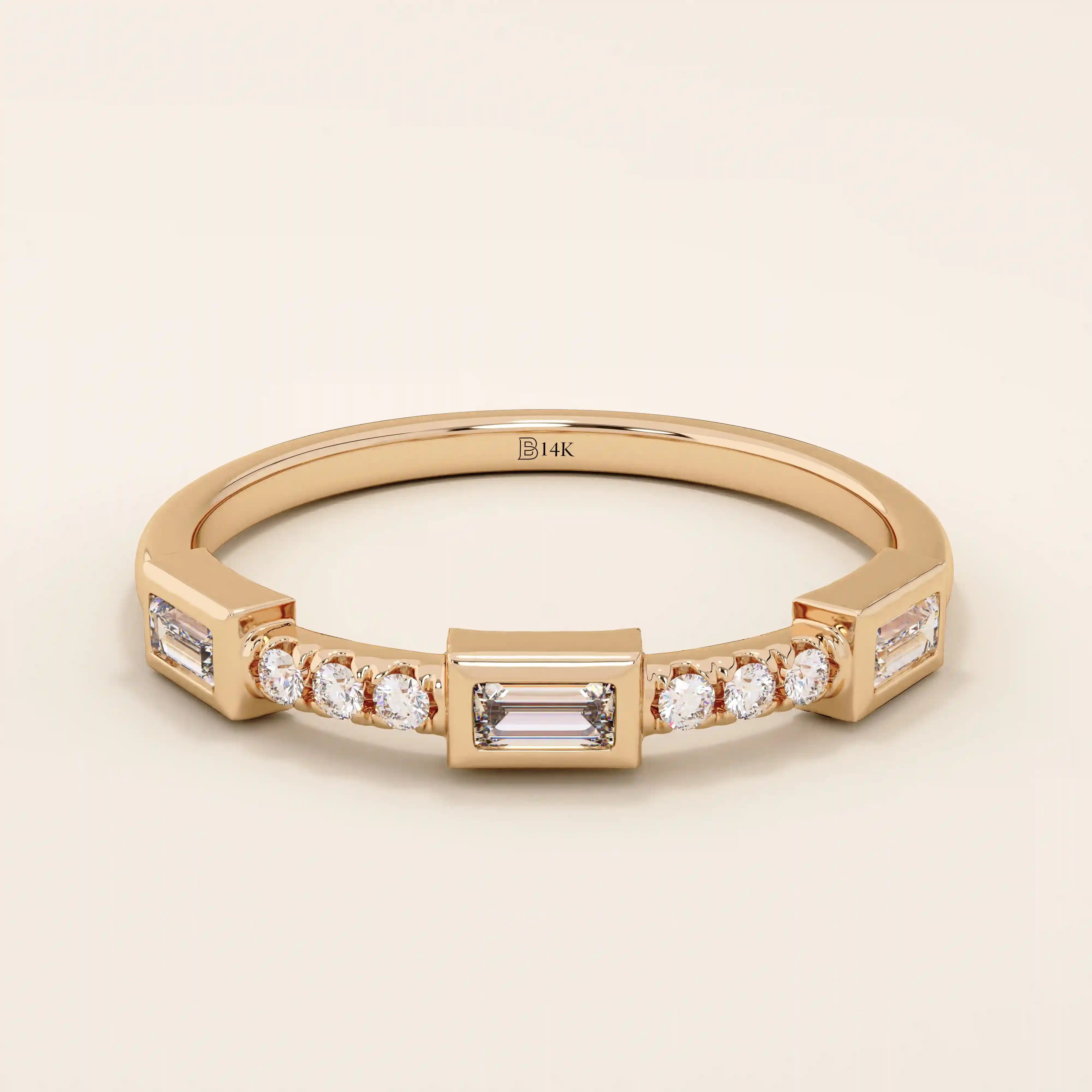 14k solid rose gold ring showcasing a baguette cut moissanite center stone with round brilliant cut moissanite accents, contemporary bezel and prong fine jewelry