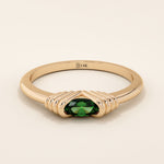 14k solid rose gold ring with an oval green gemstone secured in a ribbed split setting design.
