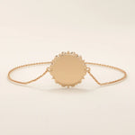 14k solid rose gold sun bracelet showcasing a round medallion with a glowing sun motif and slim chain.
