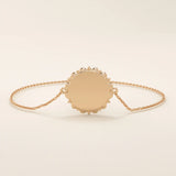 14k solid rose gold sun bracelet showcasing a round medallion with a glowing sun motif and slim chain.
