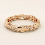 14k solid rose gold twist eternity wedding band with sculpted curves and rows of round brilliant-cut moissanites all around

