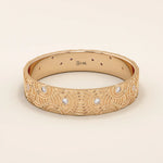 14k solid rose gold wedding band with an artistic concentric circle design and bezel-set round moissanites, elegant and unique craftsmanship
