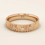 14k solid rose gold wide band showcasing a wood grain texture and three bezel set round brilliant cut moissanite stones, bold and romantic fine jewelry piece

