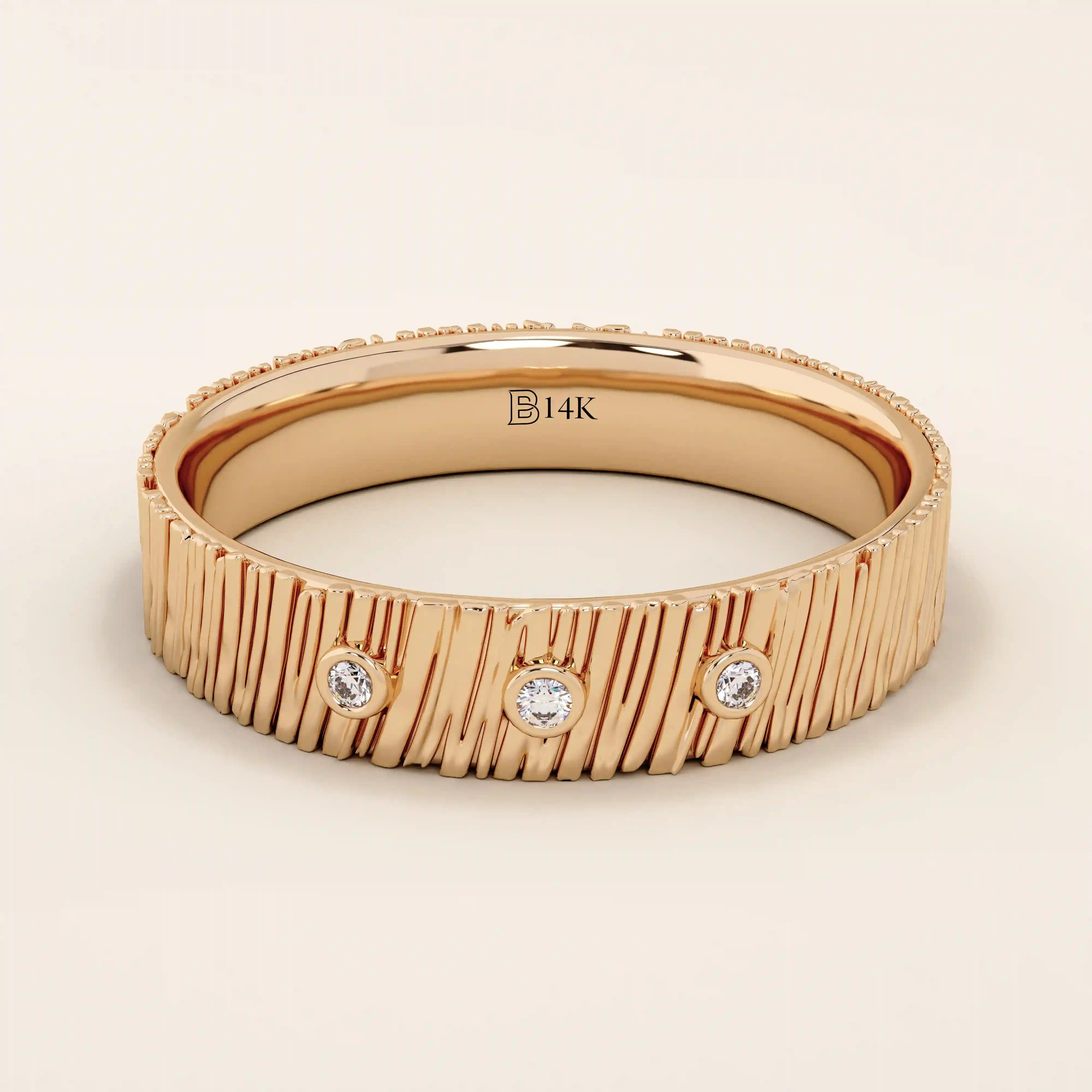 14k solid rose gold wide band showcasing a wood grain texture and three bezel set round brilliant cut moissanite stones, bold and romantic fine jewelry piece

