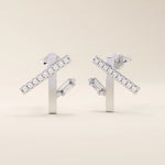 14k solid white gold geometric line stud earrings featuring pavé-set moissanite rounds on a bar with a vertical baguette stone below.
