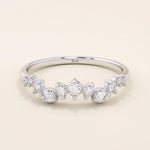 14k solid white gold ring featuring a half-eternity of alternating round moissanite stones in varied sizes.
