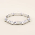 14k solid white gold ring with a repeating pattern of polished leaf shapes and bezel-set moissanites.
