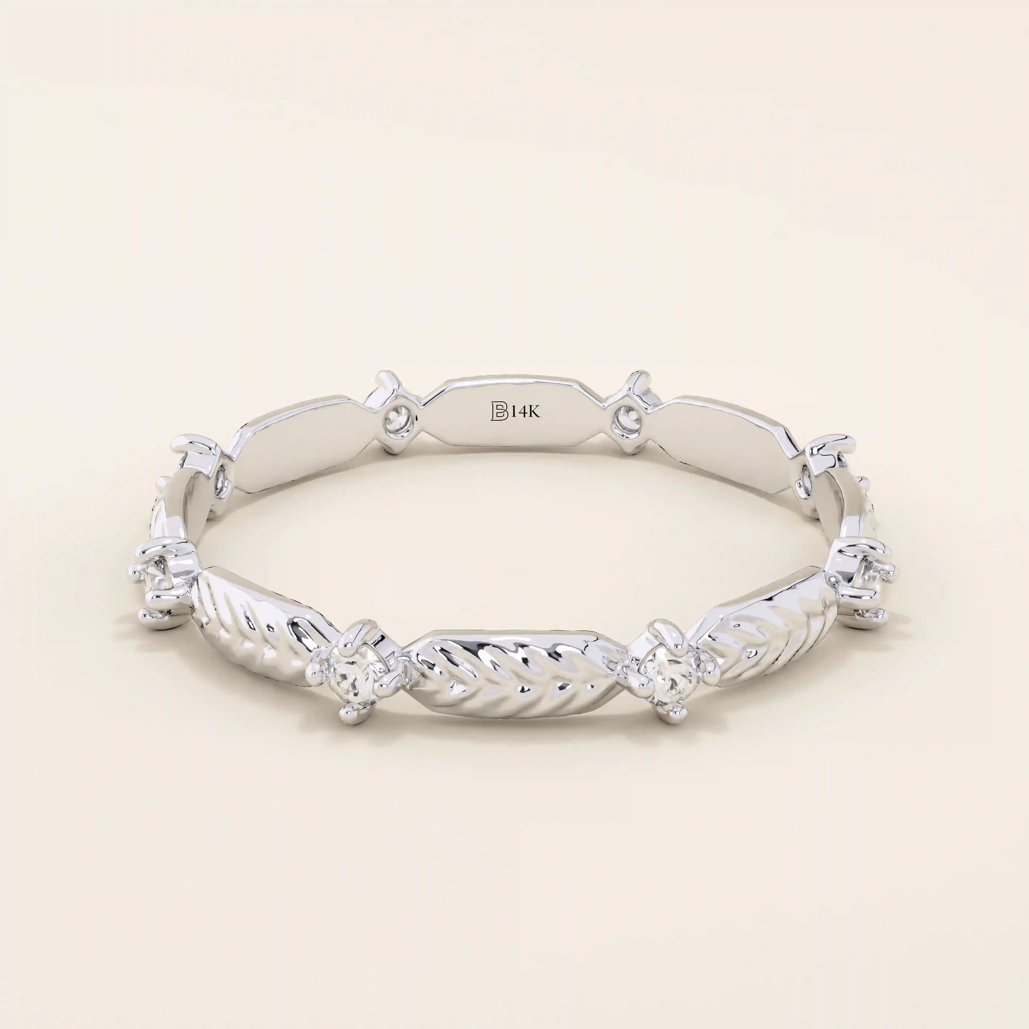 14k solid white gold ring with a repeating pattern of polished leaf shapes and bezel-set moissanites.
