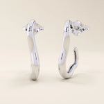 14k solid white gold sculptural hoop studs featuring an organic, abstract shape with a sleek polished surface.
