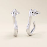 14k solid white gold sculptural hoop studs featuring an organic, abstract shape with a sleek polished surface.
