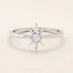 14k solid white gold starburst ring with a central round moissanite and smaller accent stones radiating along the points.
