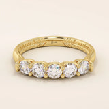 14k solid yellow gold band featuring five round brilliant cut moissanite stones in a classic prong setting with engraved detailing along the shank, timeless fine jewelry for weddings or anniversaries
