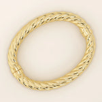 14k solid yellow gold bangle with a bold twisted rope design, featuring a high-polish finish and secure clasp closure for a luxurious, statement-making look.
