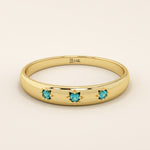 14k solid yellow gold dome ring featuring three round aquamarine gemstones set in star-shaped engravings evenly spaced across the band.