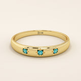 14k solid yellow gold dome ring featuring three round aquamarine gemstones set in star-shaped engravings evenly spaced across the band.