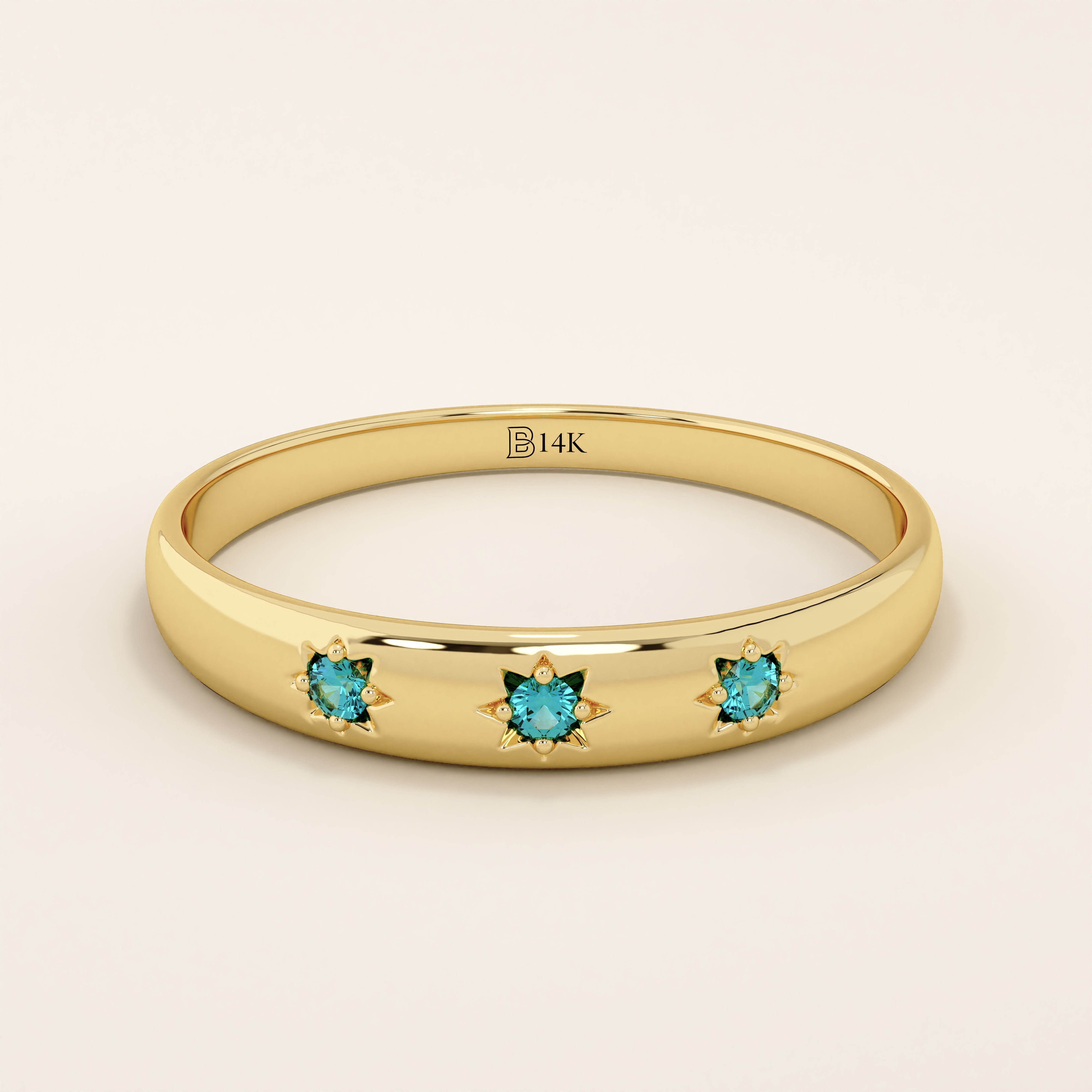 14k solid yellow gold dome ring featuring three round aquamarine gemstones set in star-shaped engravings evenly spaced across the band.
