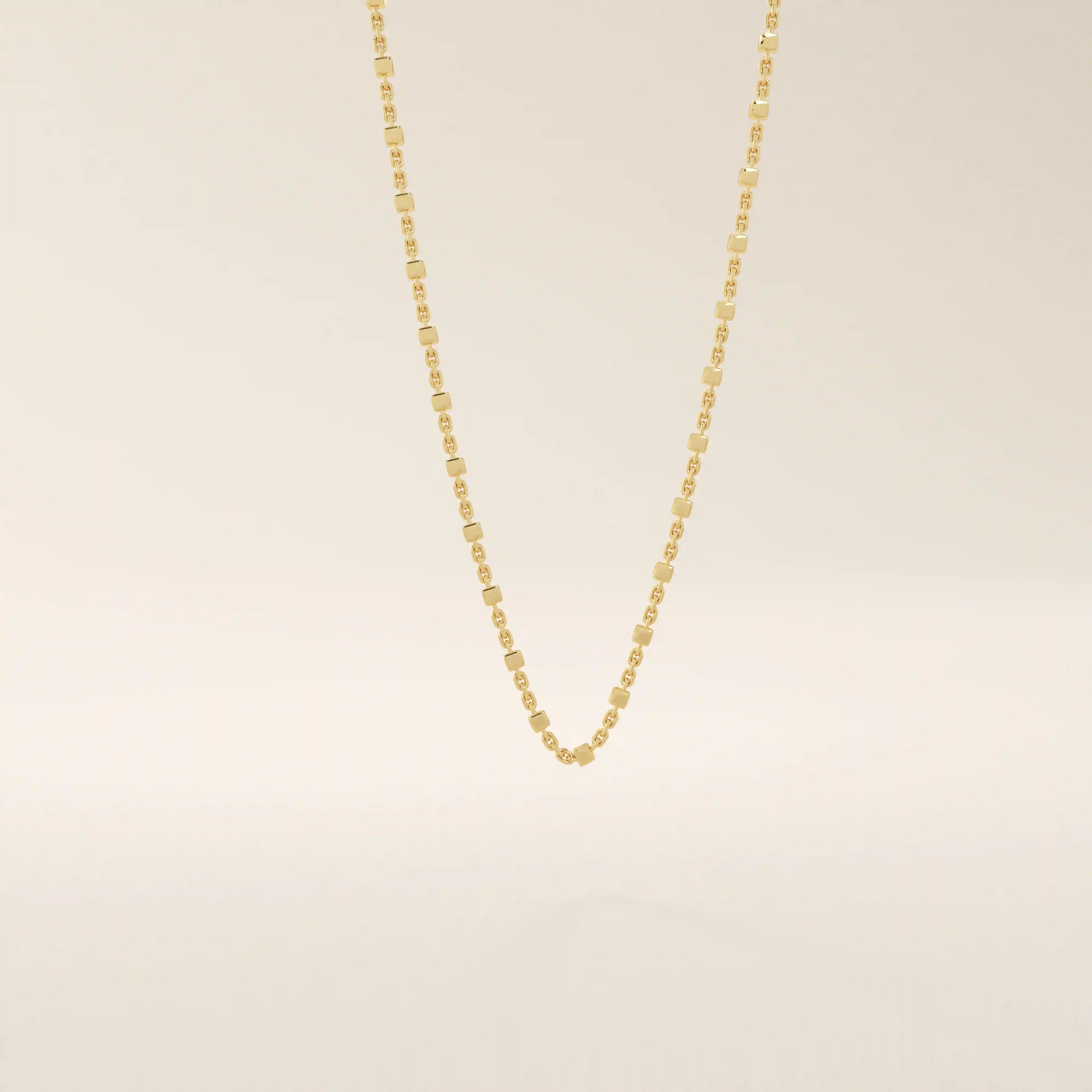 14k solid yellow gold dot chain necklace featuring small, evenly spaced flat square discs linked along a delicate chain, creating a sleek and modern everyday piece.
