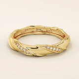 14k solid yellow gold eternity wedding band with a sculpted twist design, featuring rows of round brilliant-cut moissanites set all around
