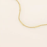 14k solid yellow gold flat bar chain necklace featuring slim, polished rectangular bar stations evenly spaced along a delicate cable chain, creating a sleek and modern accessory.
