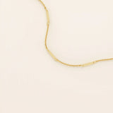 14k solid yellow gold flat bar chain necklace featuring slim, polished rectangular bar stations evenly spaced along a delicate cable chain, creating a sleek and modern accessory.
