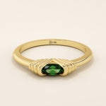 14k solid yellow gold ring featuring an oval-cut deep green gemstone held in a unique ribbed split setting.
