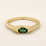 14k solid yellow gold ring featuring an oval-cut deep green gemstone held in a unique ribbed split setting.
