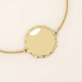 14k solid yellow gold sun bracelet featuring a round medallion with radiant sunburst details and a delicate chain.
