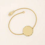 14k solid yellow gold sun bracelet featuring a round medallion with radiant sunburst details and a delicate chain.
