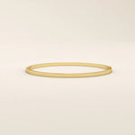 14k solid yellow gold textured square tube bangle bracelet with a slim polished band and subtle geometric detail.
