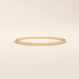 14k solid yellow gold textured square tube bangle bracelet with a slim polished band and subtle geometric detail.
