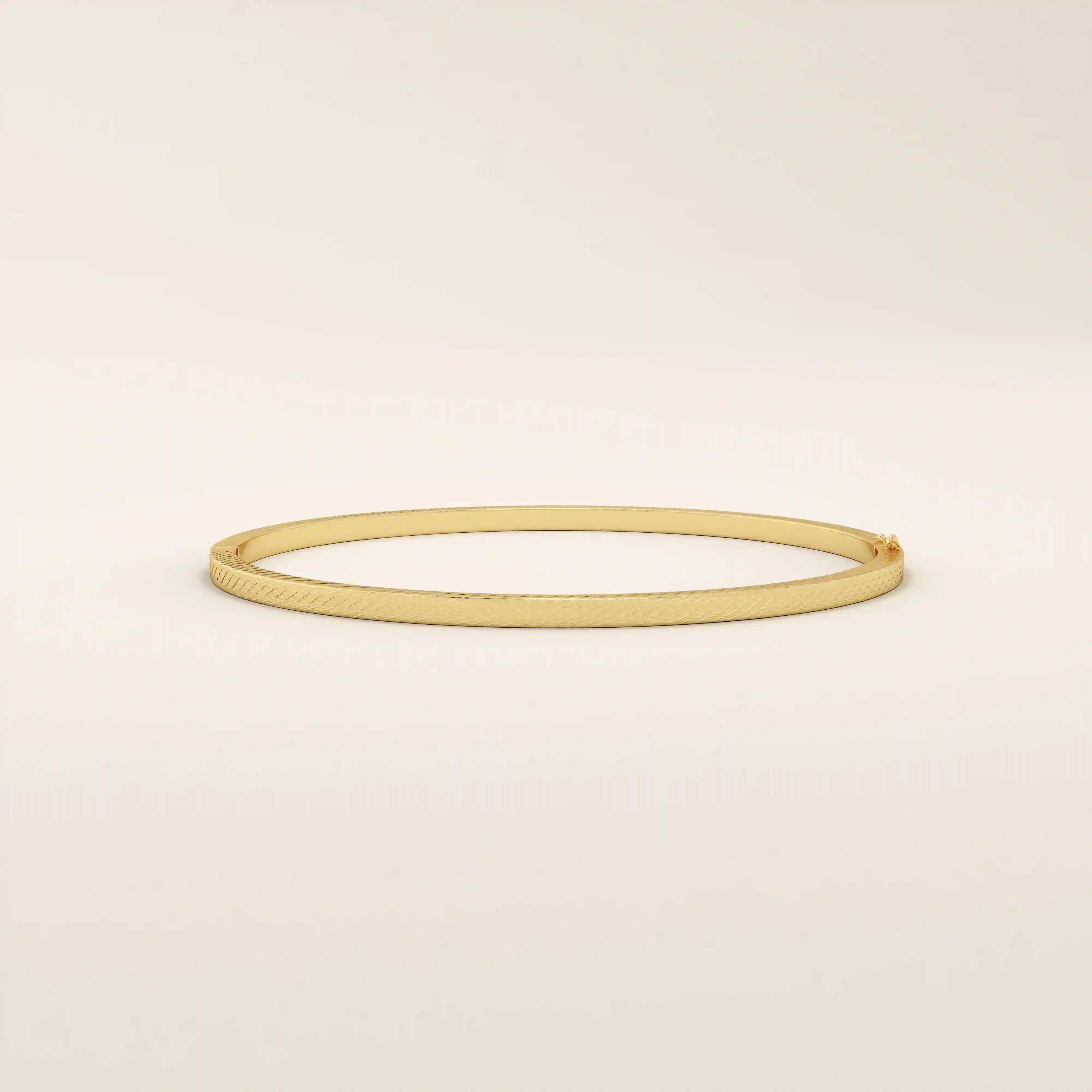 14k solid yellow gold textured square tube bangle bracelet with a slim polished band and subtle geometric detail.
