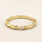 14k solid yellow gold twisted wedding band with a cluster of round brilliant moissanites set in a marquise-shaped opening, modern and elegant design
