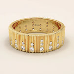 14k solid yellow gold wide wedding band featuring a wood grain texture and pavé set round brilliant cut moissanite stones in varied sizes, modern and unique fine jewelry design
