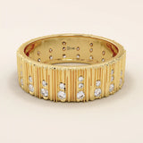 14k solid yellow gold wide wedding band featuring a wood grain texture and pavé set round brilliant cut moissanite stones in varied sizes, modern and unique fine jewelry design
