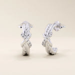 14k white gold knot stud earrings with interwoven polished and rope-textured strands accented by sparkling moissanites.
