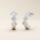 14k white gold knot stud earrings with interwoven polished and rope-textured strands accented by sparkling moissanites.
