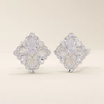 14k white gold stud earrings featuring an embossed clover motif with intricate vintage-style detailing.
