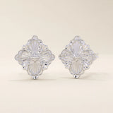 14k white gold stud earrings featuring an embossed clover motif with intricate vintage-style detailing.
