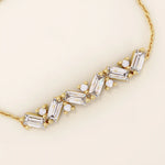 14k yellow gold baguette bar bracelet featuring baguette-cut stones and round brilliant stones set in a sleek chain.
