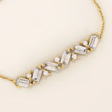 14k yellow gold baguette bar bracelet featuring baguette-cut stones and round brilliant stones set in a sleek chain.
