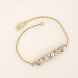 14k yellow gold baguette bar bracelet featuring baguette-cut stones and round brilliant stones set in a sleek chain.
