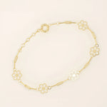14k yellow gold bracelet featuring dainty flower-shaped charms linked together with delicate chain links.
